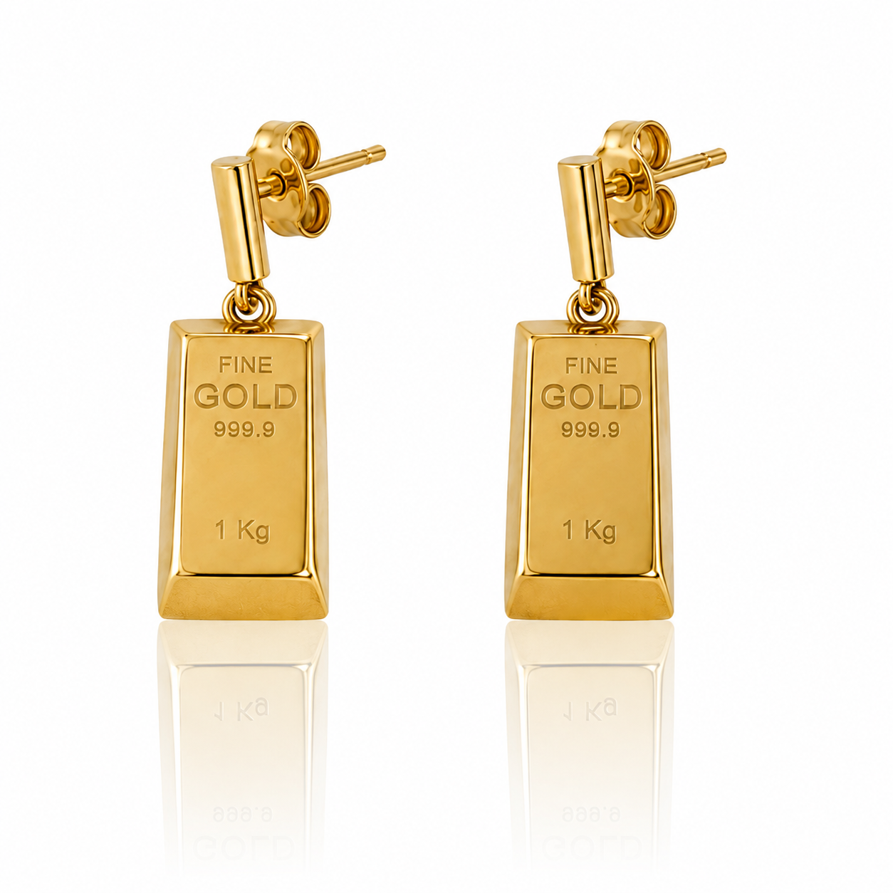 Kolczyki Sztabki to geometryczna forma inspirowana klasyczną sztabką złota. Każdy kolczyk tworzy ruchoma zawieszka z charakterystycznym grawerem „FINE GOLD 999.9” oraz „1 Kg”, połączona z prostym zapięciem na sztyft.